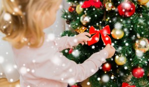 close up of little girl decorating christmas tree